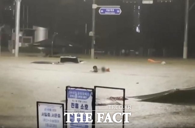 표세준 씨가 지난 8일 밤 서울 서초구 서초동 도로에서 불어난 물에 고립된 여성 운전자를 구하고 있다./유튜브 갈무리
